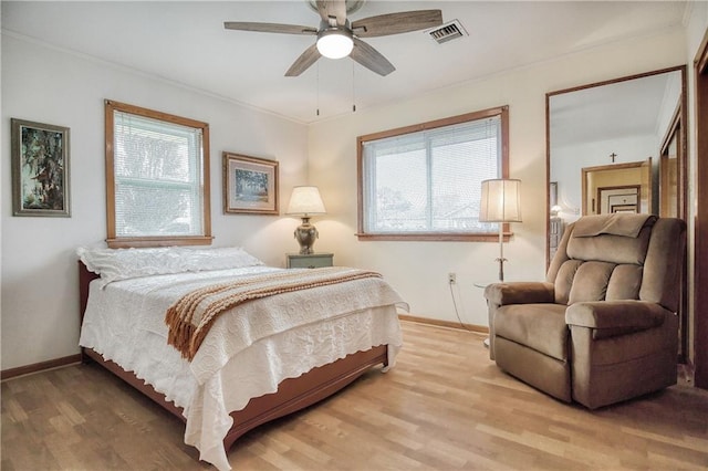 bedroom with multiple windows, crown molding, hardwood / wood-style floors, and ceiling fan