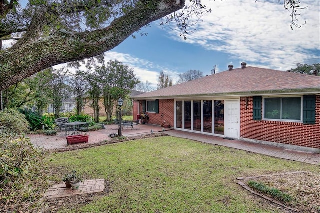 rear view of property with a yard and a patio area