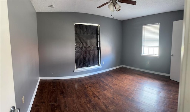 spare room with dark wood-type flooring, ceiling fan, and a textured ceiling