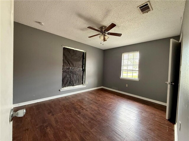 spare room with ceiling fan, dark hardwood / wood-style floors, and a textured ceiling