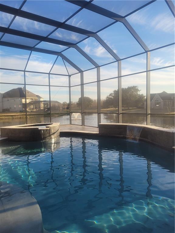 view of pool featuring pool water feature and glass enclosure