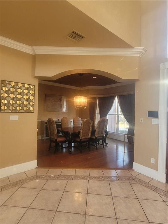 tiled dining area featuring crown molding