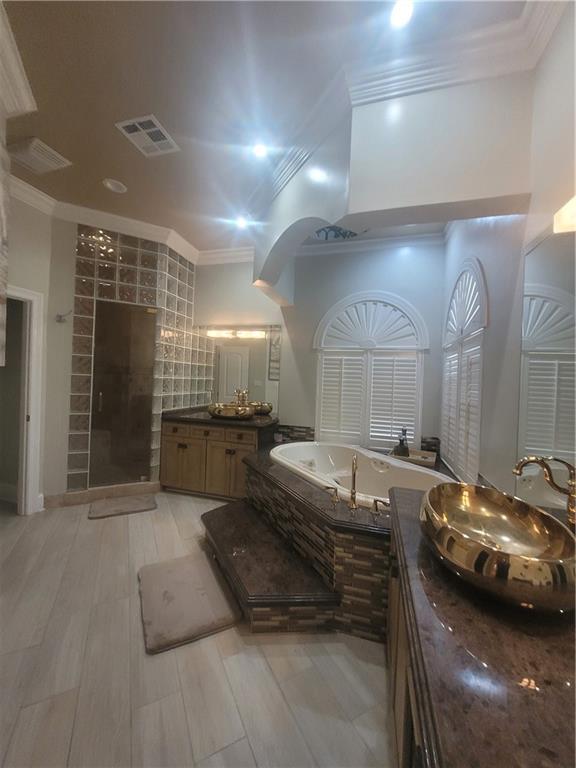 bathroom featuring crown molding, vanity, plus walk in shower, and hardwood / wood-style floors