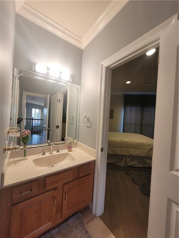 bathroom featuring ornamental molding, wood-type flooring, and vanity