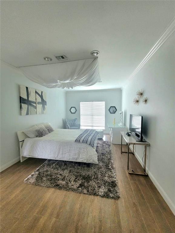 bedroom with crown molding and hardwood / wood-style flooring