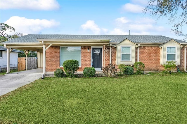 single story home featuring a shingled roof, a front yard, fence, and an attached carport