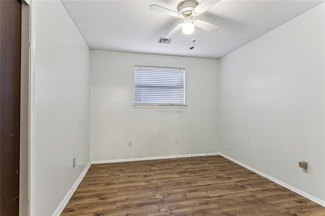 empty room with ceiling fan and dark hardwood / wood-style flooring