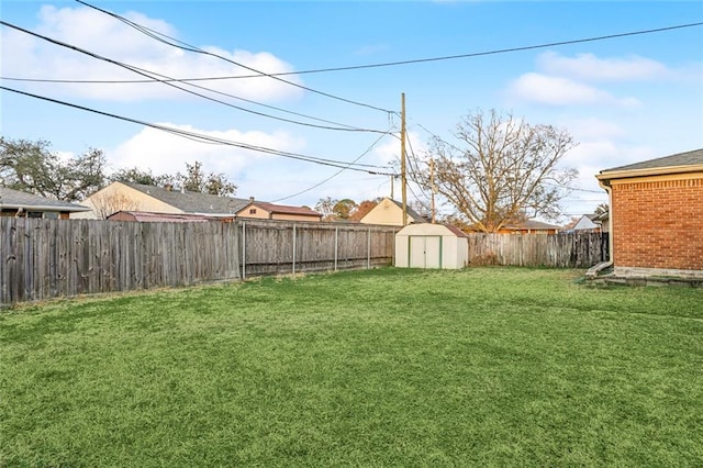 view of yard with an outbuilding, a fenced backyard, and a storage shed