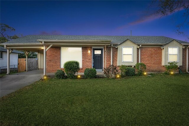 single story home featuring a lawn and a carport