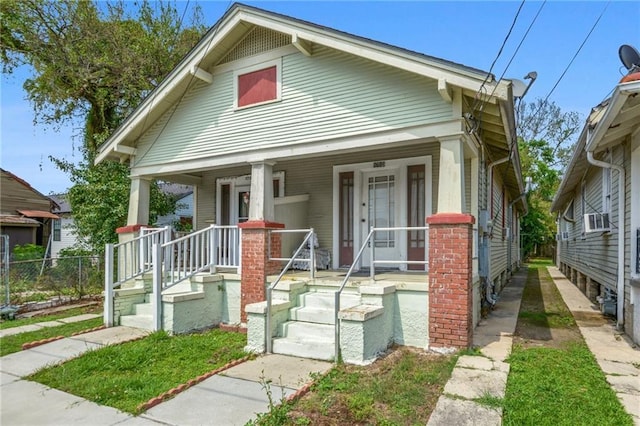 view of front of house featuring fence, a porch, and cooling unit