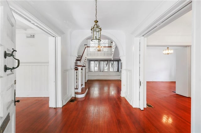 hall featuring hardwood / wood-style floors and an inviting chandelier