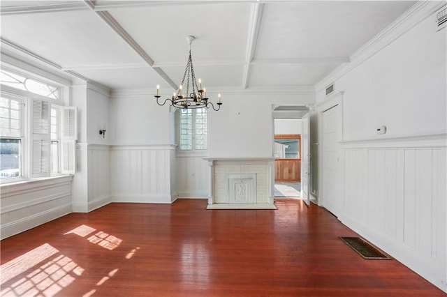 unfurnished dining area featuring hardwood / wood-style flooring, coffered ceiling, a wealth of natural light, and a notable chandelier