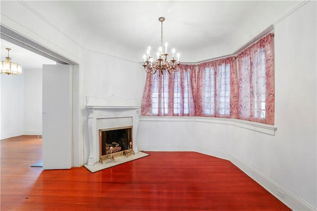 unfurnished living room with an inviting chandelier and wood-type flooring