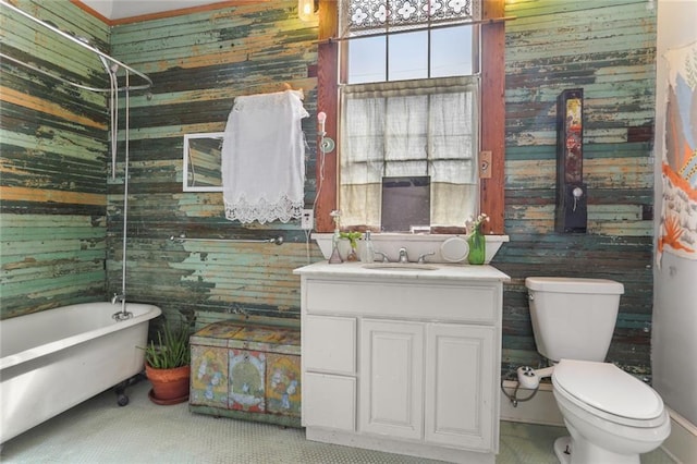 bathroom featuring vanity, toilet, and wood walls