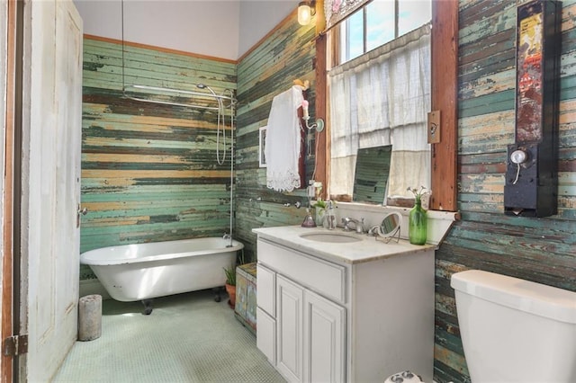 bathroom with toilet, vanity, and a bath