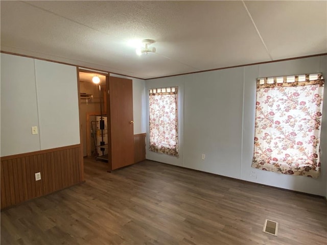 68443 S River Rd, Kentwood, LA 70444 - unfurnished bedroom with wood-type flooring, wood walls, a textured ceiling, and a closet