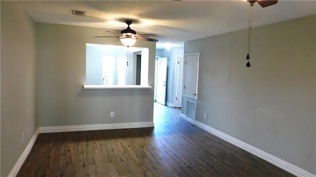 empty room with dark hardwood / wood-style floors, a textured ceiling, and ceiling fan