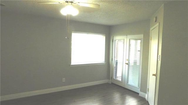 unfurnished room with ceiling fan, dark wood-type flooring, and a textured ceiling