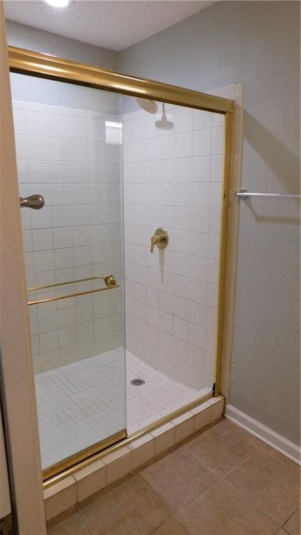 bathroom with tile patterned flooring and walk in shower