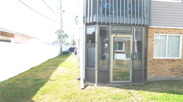 view of outbuilding with a yard and a sunroom