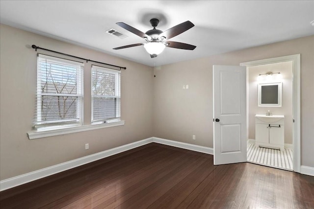 unfurnished bedroom with ceiling fan, sink, dark hardwood / wood-style flooring, and ensuite bath