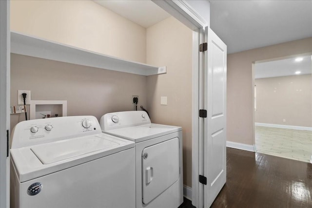 clothes washing area featuring dark hardwood / wood-style floors and separate washer and dryer