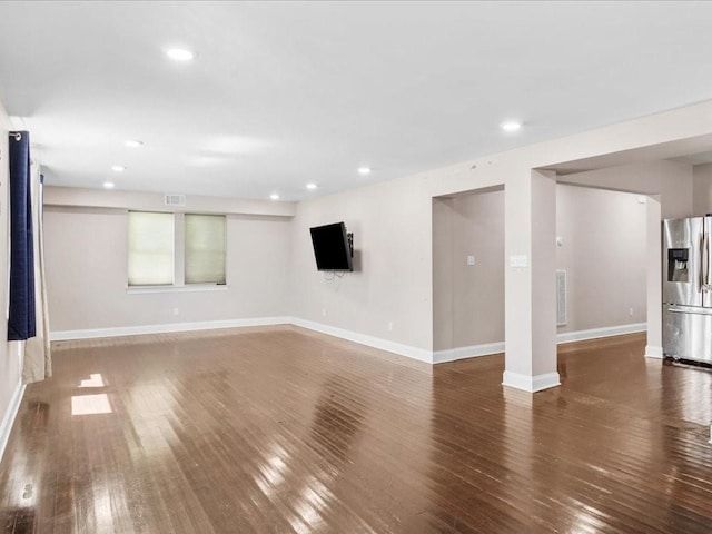 interior space with dark hardwood / wood-style floors and stainless steel refrigerator with ice dispenser