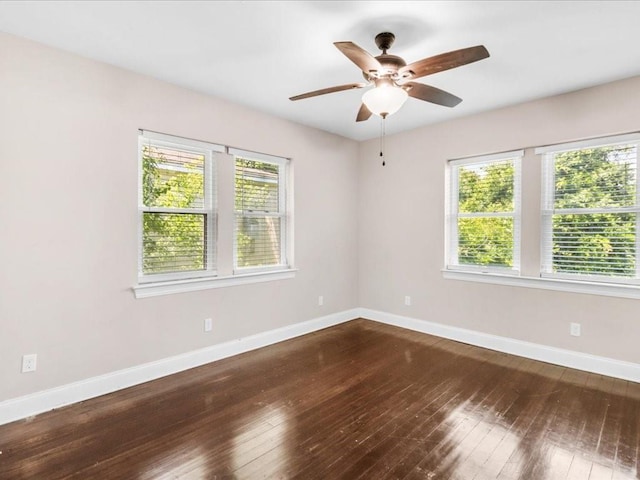 spare room with hardwood / wood-style floors, a wealth of natural light, and ceiling fan