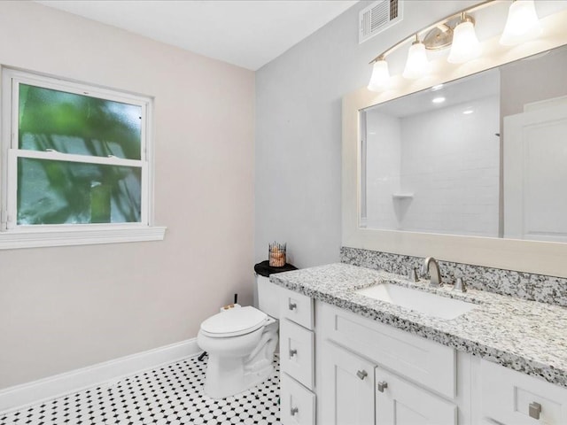 bathroom with vanity, a shower, and toilet