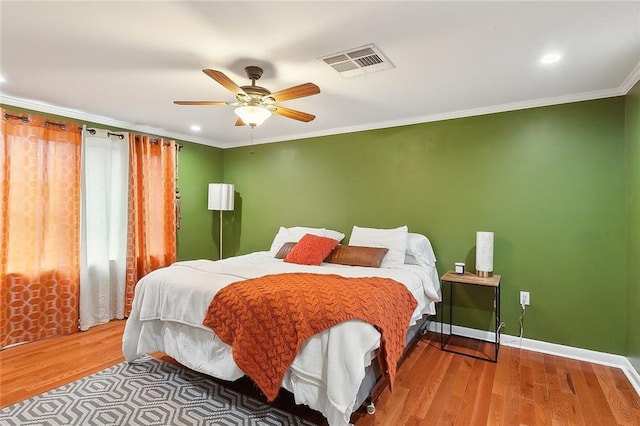 bedroom featuring ornamental molding, hardwood / wood-style floors, and ceiling fan