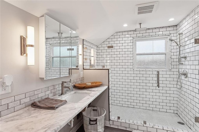 bathroom featuring a shower with door and sink