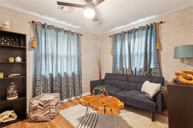 living room featuring ceiling fan and light hardwood / wood-style flooring