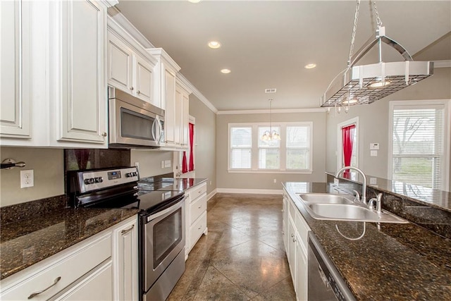 kitchen featuring decorative light fixtures, sink, white cabinets, stainless steel appliances, and crown molding