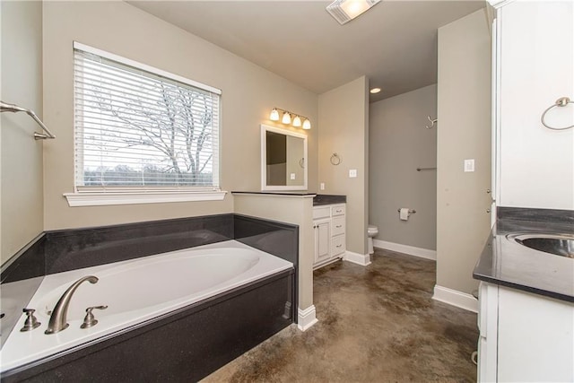 bathroom featuring vanity, a tub, and concrete floors