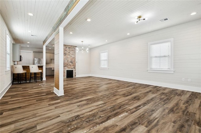 living room with dark wood-type flooring, wooden ceiling, and an inviting chandelier