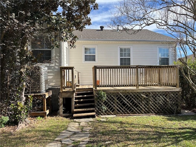 rear view of property with a wooden deck and a lawn