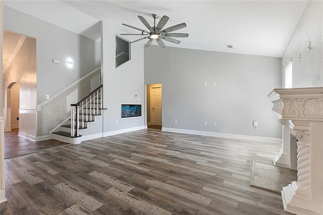 unfurnished living room with high vaulted ceiling, dark wood-type flooring, and ceiling fan