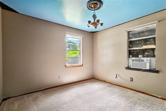 carpeted empty room with cooling unit and a chandelier