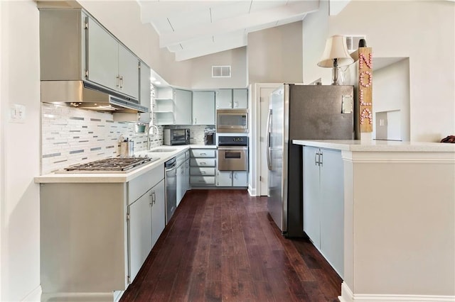 kitchen featuring tasteful backsplash, sink, lofted ceiling with beams, and stainless steel appliances