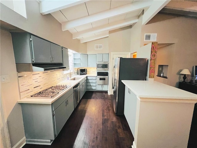 kitchen featuring sink, appliances with stainless steel finishes, backsplash, vaulted ceiling with beams, and kitchen peninsula