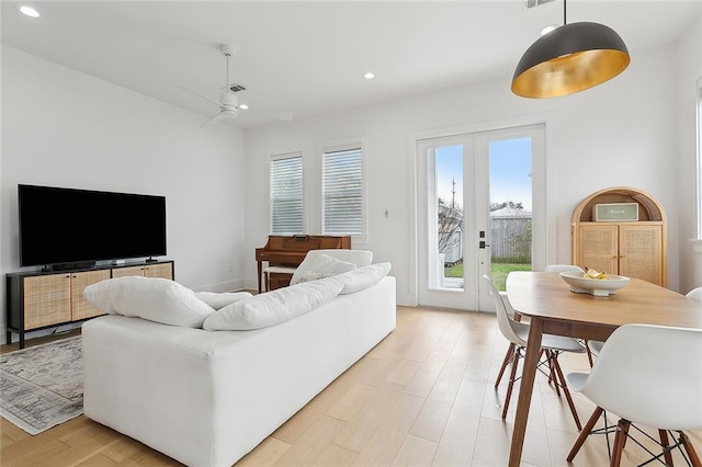 living room featuring ceiling fan, light wood-type flooring, and french doors