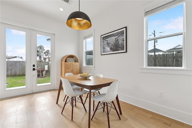 dining area with french doors and light wood-type flooring