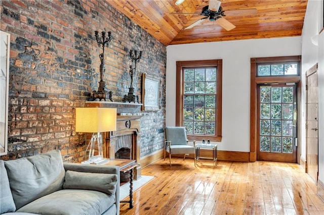 unfurnished room with wood ceiling, ceiling fan, brick wall, vaulted ceiling, and light wood-type flooring