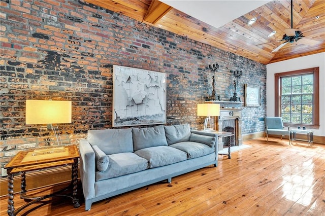 living room with lofted ceiling with beams, brick wall, light wood-type flooring, and wooden ceiling