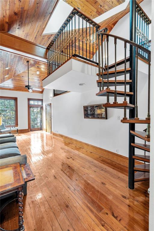 living room with hardwood / wood-style flooring, wooden ceiling, high vaulted ceiling, and beam ceiling