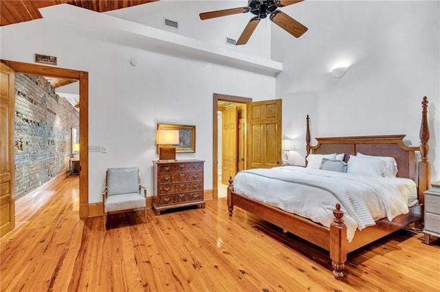 bedroom featuring ceiling fan, high vaulted ceiling, and light hardwood / wood-style flooring