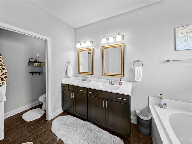 bathroom featuring toilet, vanity, and a bath