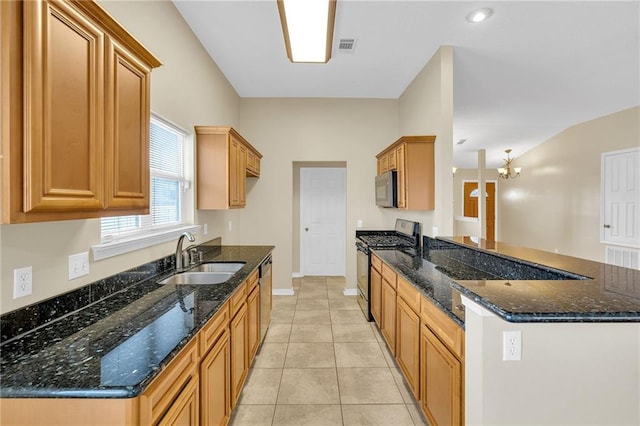 kitchen featuring sink, light tile patterned flooring, dark stone counters, and appliances with stainless steel finishes