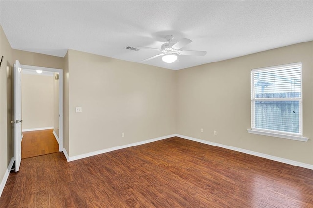 unfurnished room with a textured ceiling, dark hardwood / wood-style floors, and ceiling fan