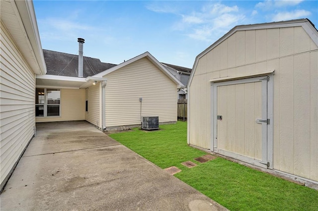 exterior space featuring a yard, central air condition unit, and a storage unit